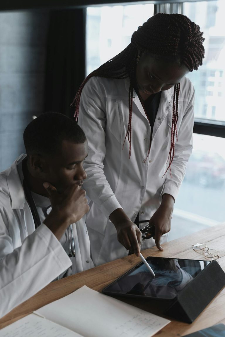Two doctors in lab coats focus on research in a modern office setting, collaborating effectively.